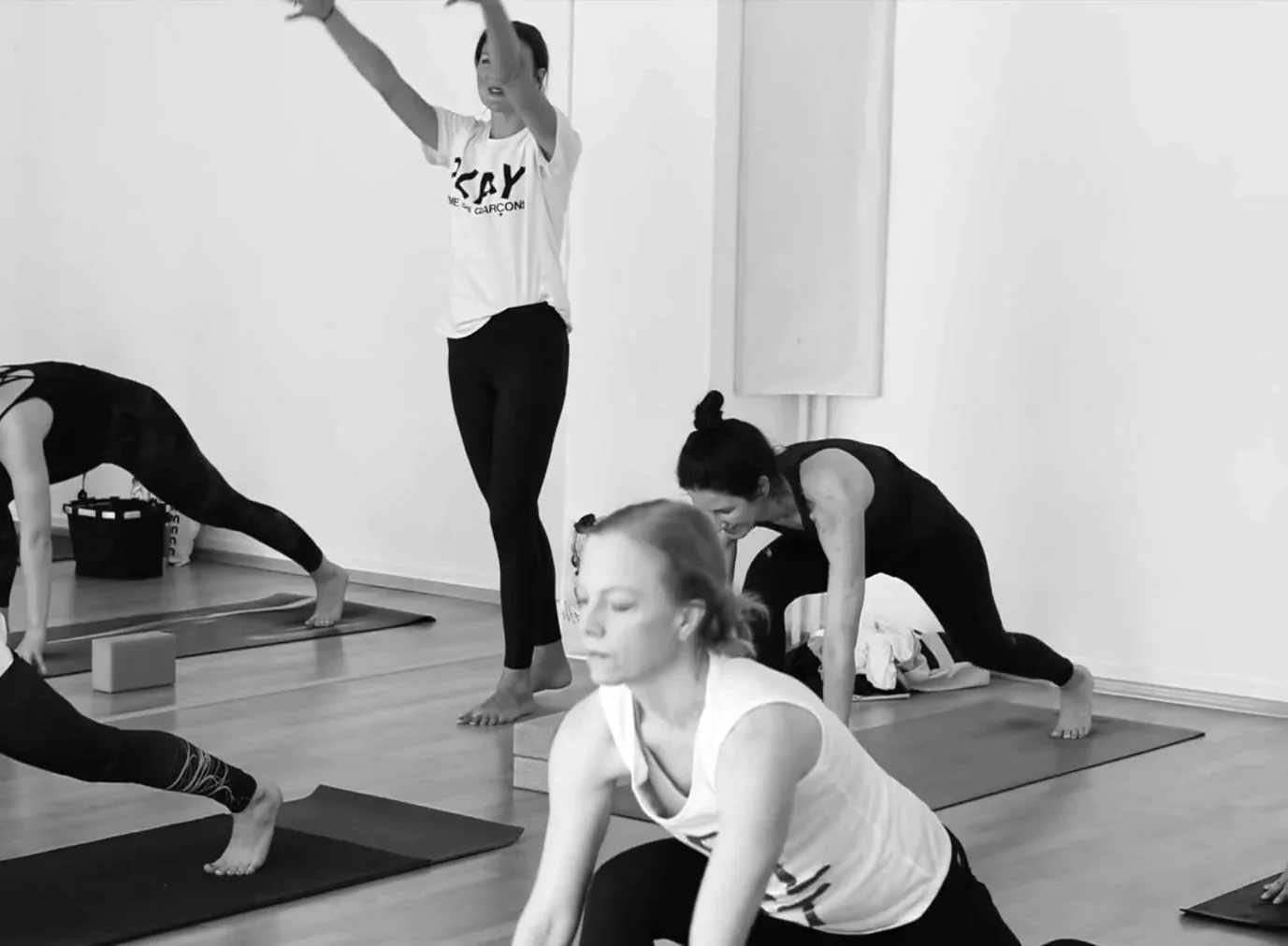 A class in downward dog while the teacher moves through the room